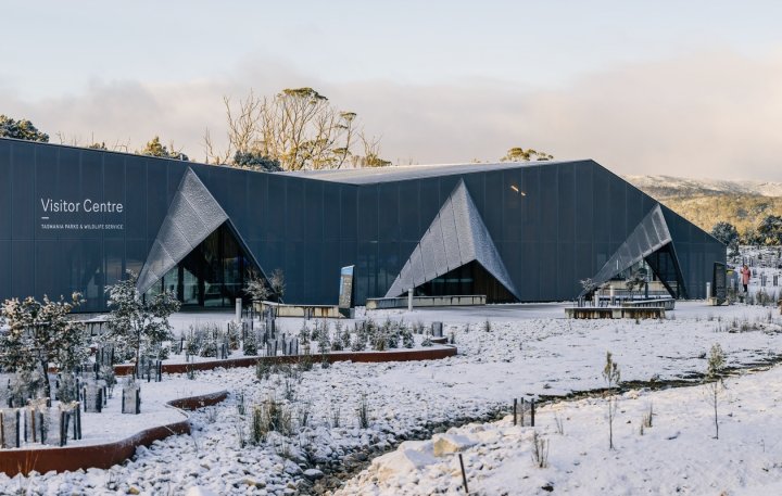 Cradle Mountain Visitor Centre, Tasmania recedes in its natural environment. Featuring roofing made from COLORBOND steel in the colour Basalt