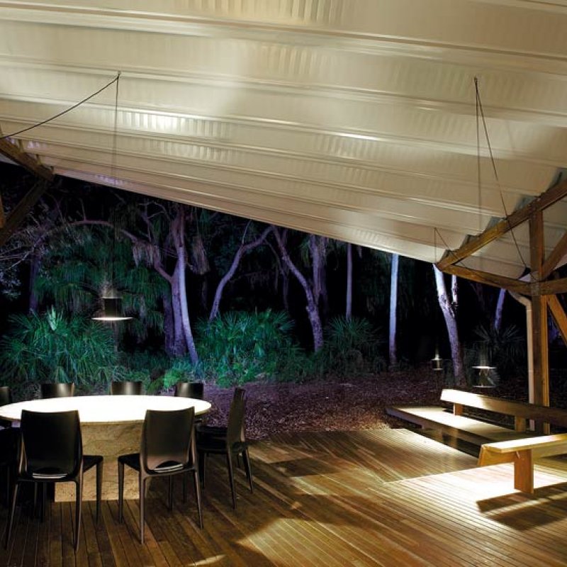 Outdoor living is on a timber deck under the swooping roof.