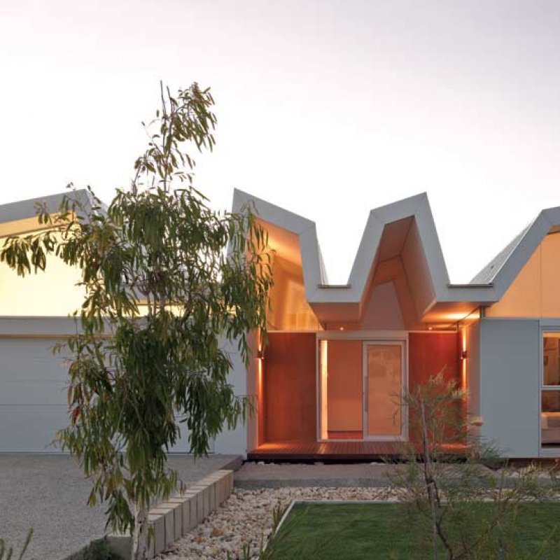 From the street, one can observe the composition of hovering platform, ribbons of glass and vaulted roof bays, which combine to set this house apart from its neighbours.