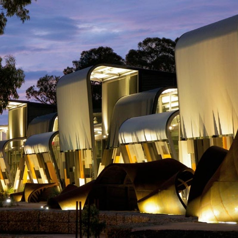 Apart from the remarkable facade, what gives the building character is the surging, undulating roofscape of split, curved roofs in three colours. 